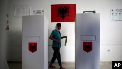 Seorang pemilih menyalurkan hak pilihnya di sebuah TPS di kota Kamez, Albania tengah, 30 Juni 2019. 