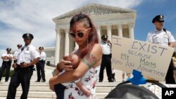 Manifestation devant la Cour suprême contre l'interdiction de l'avortement. Au premier plan, une jeune mère originaire du Maryland est venue avec sa fille de trois semaines, 21 mai 2019, Washington. 