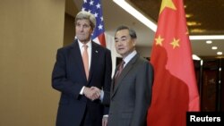 U.S. Secretary of State John Kerry, left, and Chinese Foreign Minister Wang Yi shake hands before their bilateral meeting at the Ministry of Foreign Affairs in Beijing, Jan. 27, 2016. 