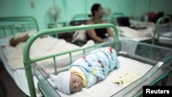 FILE - A newborn rests near his mother at a hospital in Camaguey, Cuba, June 2015. It was in that month that the WHO named Cuba the first country in the world to eliminate the transmission of HIV and syphilis from mother to child.