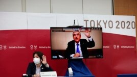 International Olympic Committee (IOC) president Thomas Bach (on-screen) and Tokyo 2020 president Seiko Hashimoto, left, wave at the beginning of the five-party meeting in Tokyo, Thursday, July 8, 2021. (Behrouz Mehri/Pool Photo via AP)