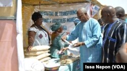 Le Premier ministre du Burkina Faso devant le stand d'une productrice dans la commune de Meguet, le 11 février 2019. (VOA/Issa Napon)