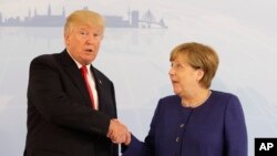 Nan Somè G20 yo, Prezidan ameriken an, Donald Trump, agoch, ak Chanselye almand lan, Angela Merkel nan Hamburg, Almay, 6 jiyè 2017.