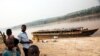 Quelques personnes à côté d'un bateau vide, sur le bord de la rivière Kasaï, au port de Tshikapa, en République démocratique du Congo, le 28 juillet 2017. 