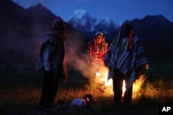 In this April 4, 2018 photo, Andean farmers take part in a ceremony honoring Mother Earth and Father Snowy Mountain, in Pitumarca, Peru. The surge in tourists comes with a responsibility to be good stewards of the environment