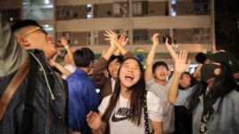 Pro-democracy supporters celebrate after pro-Beijing politician Junius Ho lost his election in Hong Kong, early Monday, Nov. 25, 2019.