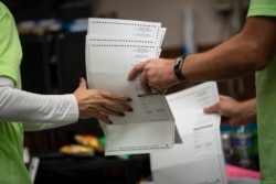 Poll workers sort out early and absentee ballots at the Kenosha Municipal building on Election Day, late Tuesday, Nov. 3, 2020, in Kenosha, Wis.