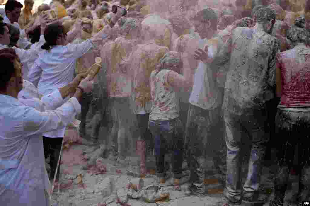 Food is poured on freshman year medical students by the faculty of medicine staff at the University of Granada, in Granada, Spain.