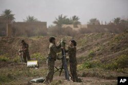 U.S.-backed Syrian Democratic Forces (SDF) soldiers prepare to fire mortars at Islamic State militant positions in Baghuz, Syria, March 13, 2019.