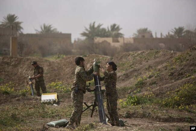 U.S.-backed Syrian Democratic Forces (SDF) soldiers prepare to fire mortars at Islamic State militant positions in Baghuz, Syria, March 13, 2019.