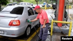 A gas station worker pumps gas into a car at a gas station of the Venezuelan state-owned oil company PDVSA in Caracas, Venezuela September 24, 2018. 