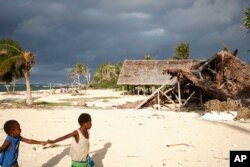 FILE - Children play on the beach in the town of Takara, on Efate Island, Vanuatu, May 30, 2015. The town was damaged in March of that year during Cyclone Pam. Many people in the town considered rebuilding on higher ground to escape what they thought were the ongoing effects of climate change.