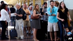 People stand in line at Washington's Reagan National Airport after technical issues at a Federal Aviation Administration center in Virginia caused delays, Aug. 15, 2015.