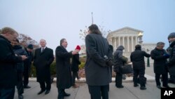 La gente fuera de la Corte Suprema antes de que los jueces escuchen argumentos en un caso presentado por los propietarios de armas en la ciudad de Nueva York, en Capitol Hill, Washington, el lunes 2 de diciembre de 2019.