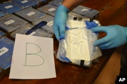 Un policía argentino muestra un paquete de cocaína con un símbolo de estrella que fue encontrado en un anexo de la Embajada de Rusia en Buenos Aires. La foto, tomada el 14 de diciembre de 2016, fue proporcionada por el Ministerio de Seguridad de Argentina el 22 de febrero de 2018.
