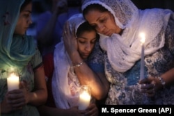 In this Monday, August 6, 2012 file photo, Sikh worshipers gather for a candlelight vigil after prayer services at the Sikh Religious Society of Wisconsin in Brookfield, Wisconsin.