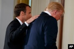 President Donald Trump and French President Emmanuel Macron walk off after a news conference in the East Room of the White House, April 24, 2018, in Washington.
