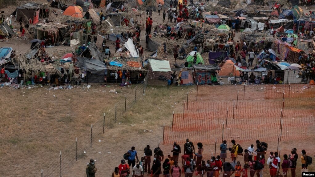 Migrantes esperan ser procesados en un campamento improvisado a lo largo del Puente Internacional en Del Rio, Texas, EE. UU., el 21 de septiembre de 2021.