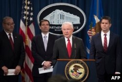 Attorney General Jeff Sessions, center, announces the creation of a new initiative to crack down on Chinese intelligence officials pilfering intellectual property from U.S. corporations during a press conference in Washington, Nov. 1, 2018.