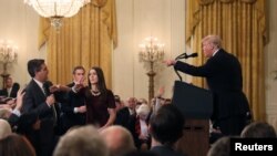 Une stagiaire de la Maison Blanche tente de prendre le micro des mains de Jim Acosta, Washington, le 7 novembre 2018.