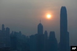 FILE - The skyline of the business district is silhouetted at sunset in Hong Kong.