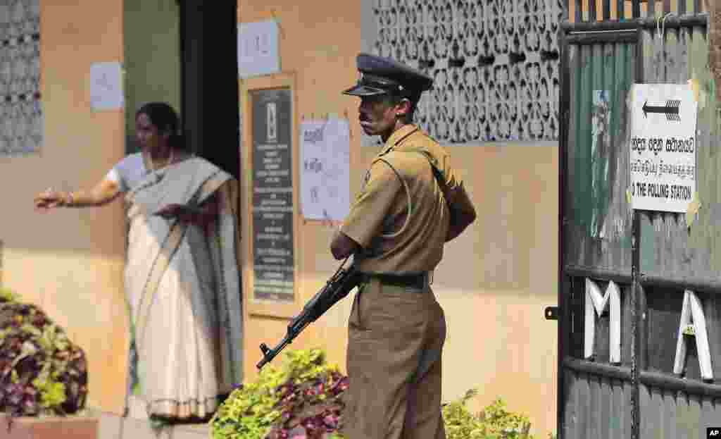 A Sri Lankan police officer stands guard at a polling station during the presidential elections in Colombo, Sri Lanka, Jan. 8, 2015.&nbsp;