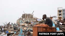 Un survivant est assis parmi les débris laissés par l'explosion la veille au quartier de Mpila à Brazzaville, le 5 mars 2012. (Photo: Patrick Fort /AFP)