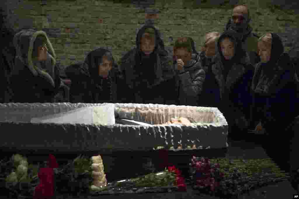 Relatives and friends pay their last respects while passing the coffin of Boris Nemtsov, a charismatic Russian opposition leader and sharp critic of President Vladimir Putin, during a farewell ceremony inside the Sakharov Center in Moscow, Russia, Tuesday, March 3, 2015.