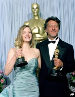 Oscar winners Jodie Foster, left, and Dustin Hoffman pose with their statuettes backstage at the Academy Awards in Los Angeles, March 29, 1989.