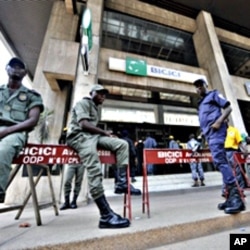 Security contain clients standing outside the headquarters of the Bicici bank as they came to withdraw money in Abidjan, March 3, 2011