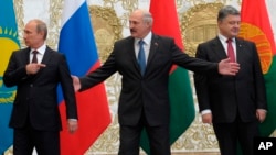 From left, Russian President Vladimir Putin, Belarusian President Alexander Lukashenko and Ukrainian President Petro Poroshenko stand before posing for a photo prior to talks in Minsk, Belarus, Tuesday, Aug. 26, 2014.
