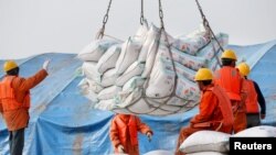 Công nhân vận chuyển các sản phẩm đậu nành nhập khẩu tại một hải cảng ở Nam Thông, tỉnh Giang Tô, Trung Quốc, ngày 22 tháng 3, 2018
