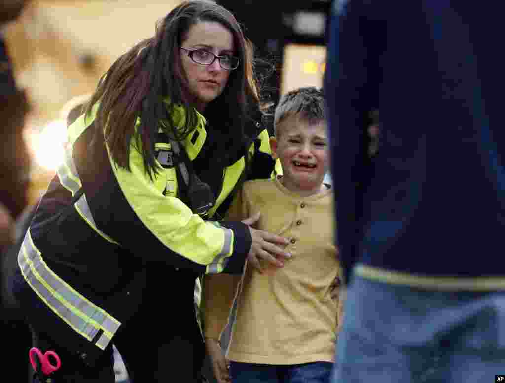 Officials guide students off a bus and into a recreation center where they were reunited with their parents after a shooting at a middle school in Highlands Ranch, Colorado, May 7, 2019.