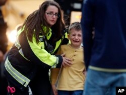 Officials guide students off a bus and into a recreation center where they were reunited with their parents after a shooting at a suburban Denver middle school in Highlands Ranch, Colorado, May 7, 2019.