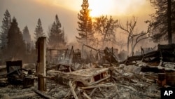 A vintage car rests among debris as the Camp Fire tears through Paradise, Calif., on Nov. 8, 2018. 