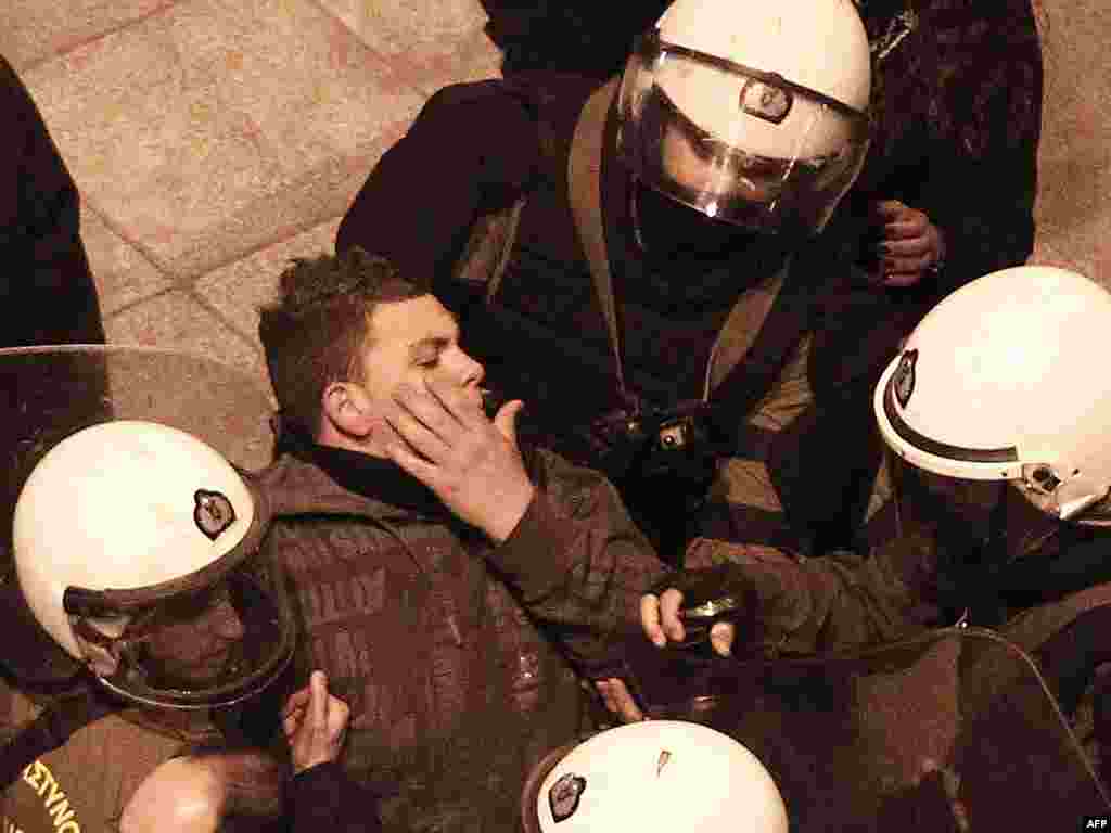 Riot police detain a protester during a small demo at Athens' main Syntagma Square on February 19, 2012. (AP)