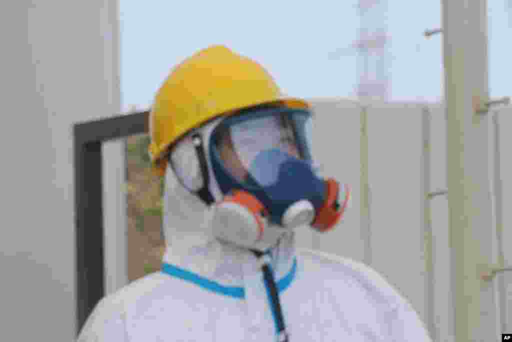 One of the gate guards in a hazmat suit, helmet and dual intake respirator, April 13, 2011 (VOA Photo S. Herman)