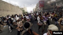Anti-Houthi protesters run as pro-Houthi police troopers open fire in the air to disperse them, in Yemen's southwestern city of Taiz, March 23, 2015.