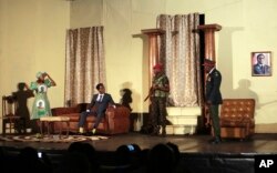 In this photo taken March, 28, 2018, actor Caroline Magenga, playing former Zimbabwean first lady Grace Mugabe, left, reacts as armed soldiers enter her house during a play dramatizing the events leading to Mugabe's resignation, in Harare, Zimbabwe.