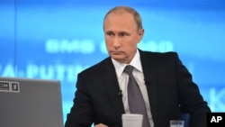 Russian President Vladimir Putin listens during an annual call-in show on Russian television "Conversation With Vladimir Putin" in Moscow, Russia, Thursday, April 16, 2015. Speaking Thursday in a televised call-in show with the nation, Putin said the nation's economic performance has remained strong, despite Western sanctions slapped on Russia over the Ukrainian crisis and a slump in global oil prices. (Alexei Druzhinin/RIA Novosti, Presidential Press Service via AP)