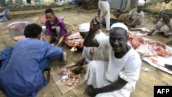 Sudanese protesters cut the meet of sheep and cows that they slaughtered on April 16, 2019, as they celebrate the ousting of longtime leader Omar al-Bashir, outside the army complex in the capital Khartoum, where they have been camping out for days.