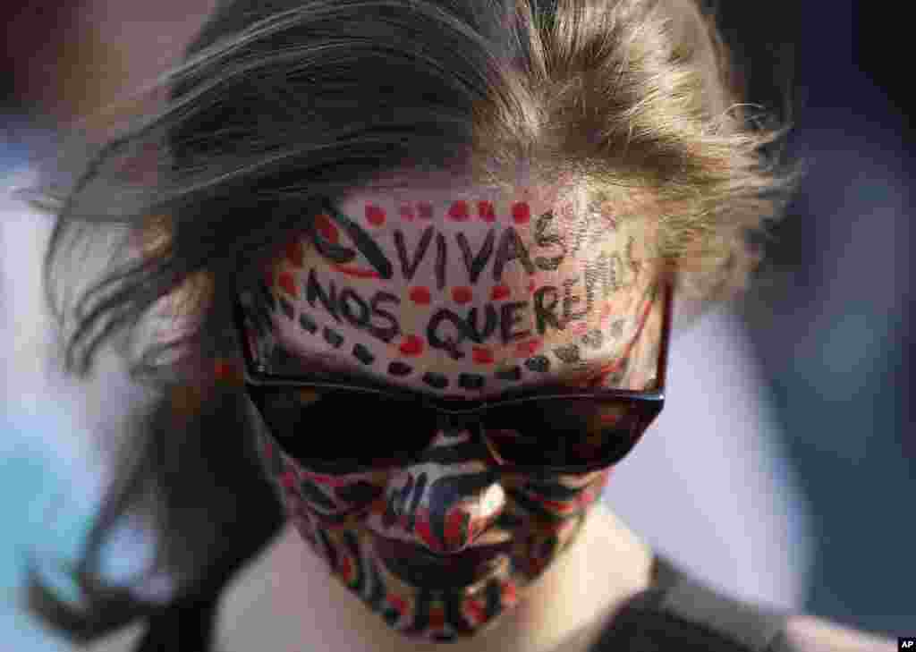 Seorang perempuan dengan wajah dilukis memprotes kekerasan berbasis gender di Mexico City (19/11). Para perempuan di seluruh Amerika Latin berpartisipasi dalam protes melawan pemerkosaan dan pembunuhan seorang gadis remaja di Argentina. (AP/Marco Ugarte)