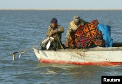 Kazakh fishermen pull a fishing net from a boat at Kokaral near the village of Karateren, southwestern Kazakhstan. Once the world's fourth largest lake, the Aral has shrunk so much that it has now split into two separate bodies of water.