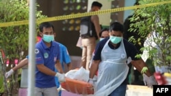 Paramedics take away a body after four Thai civil defense volunteers were shot and killed outside of a school in the restive southern province of Pattani, Thailand, Jan. 10, 2019.