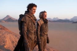 Timothee Chalamet (kiri) dan Rebecca Ferguson dalam sebuah adegan film "Dune" yang akan dirilis bulan Oktober mendatang (dok: Chia Bella James/Warner Bros. Entertainment via AP)