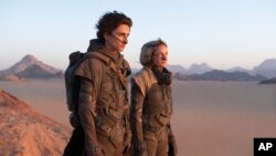 Timothee Chalamet (kiri) dan Rebecca Ferguson dalam sebuah adegan film "Dune" yang akan dirilis bulan Oktober mendatang (dok: Chia Bella James/Warner Bros. Entertainment via AP) 
