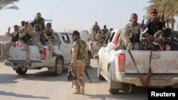 Pejuang Syiah dan tentara Irak berpatroli di Jurf al-Sakhar (25/10). Seorang pembom bunuh diri menyerang pos keamanan di pinggiran kota ini, menewaskan 11 orang dan melukai 23 lainnya, Senin (27/10).