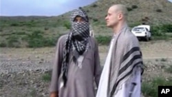 FILE - In this image taken from video obtained from the Voice of Jihad website in June 2014, Army Sgt. Bowe Bergdahl, right, stands with a Taliban fighter in eastern Afghanistan.