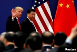 FILE - U.S. President Donald Trump and China's President Xi Jinping meet business leaders at the Great Hall of the People in Beijing, China, Nov. 9, 2017.