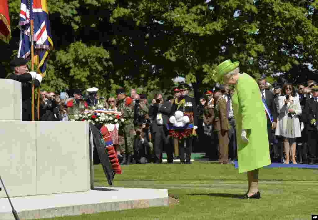 Britanska kraljica Elizabeta odaje poštu posle polaganja venca tokom francusko-britanske svečanosti na groblju britanskih vojnika u Baju, Normandiji. 6. jun, 2014.